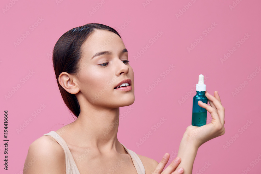 Young woman with natural makeup holding a skincare serum against a pink background, showcasing healthy skin and beauty products Young woman with natural makeup holding a skincare serum against a pink background, showcasing healthy skin and beauty products