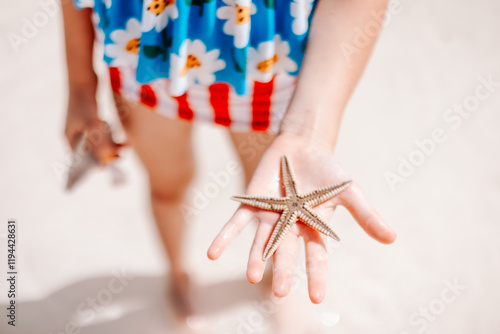 Child's Hand Holding a Starfish at the Bahamas photo