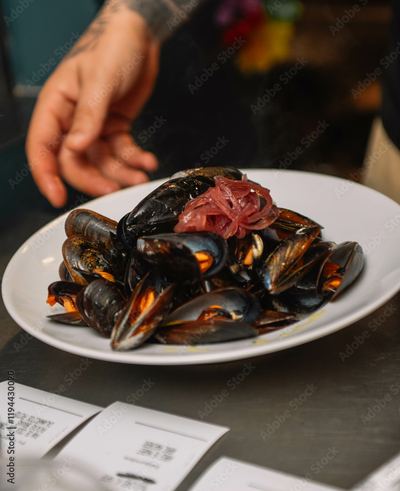 Steamed mussels on a white plate in a restaurant. Restaurant Steamed mussels on a white plate in a restaurant. Restaurant