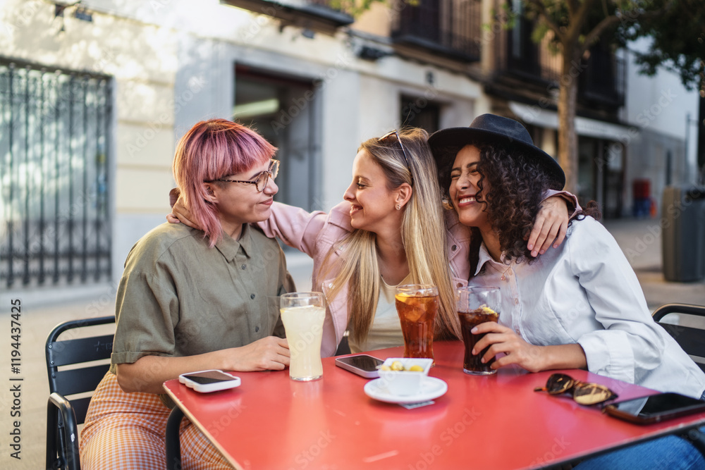 Three happy friends enjoying drinks and conversation at outdoor cafe Three happy friends enjoying drinks and conversation at outdoor cafe