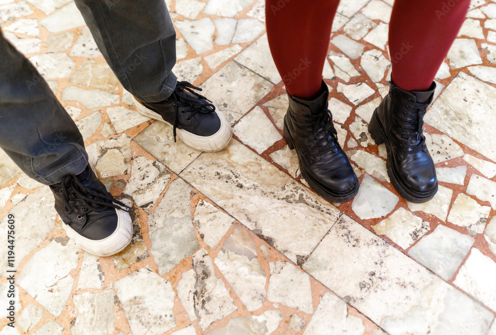 Two people standing next to each other with their feet on a tile floor Two people standing next to each other with their feet on a tile floor