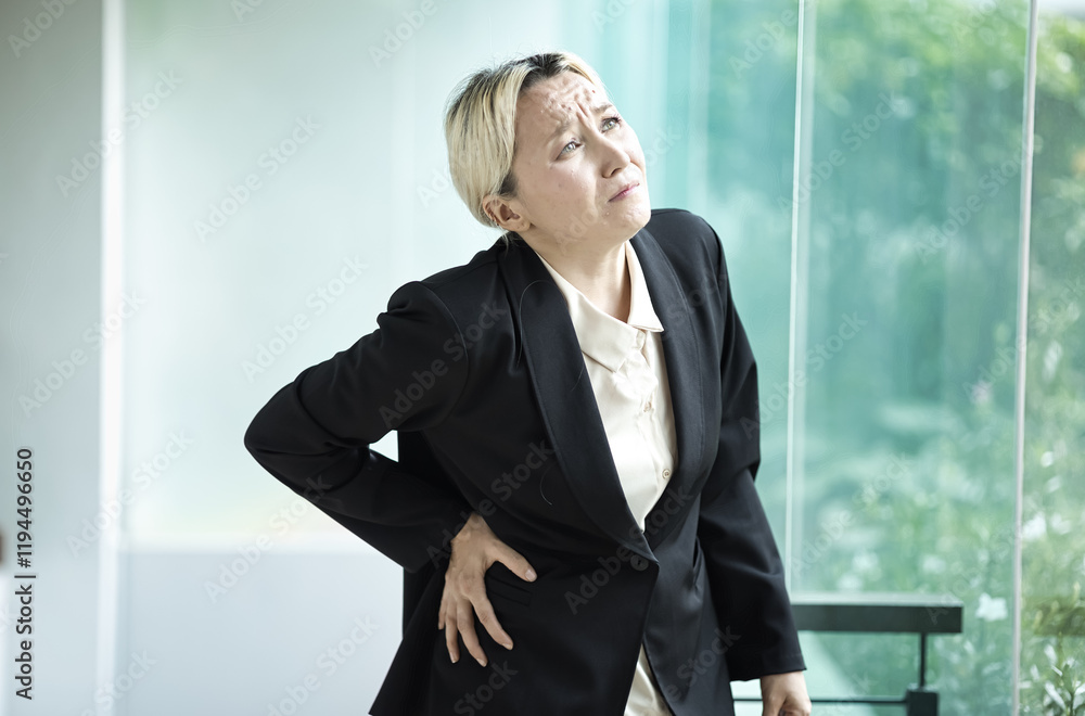 Unwell and sick middle aged woman in office syndrome Distress, Dealing with lower back pain, work-related spinal issue, herniated disc, Healthcare concept Unwell and sick middle aged woman in office syndrome Distress, Dealing with lower back pain, work-related spinal issue, herniated disc, Healthcare concept