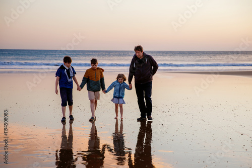 Portrait silhouettes of three children and dad happy kids with father on beach at sunset. happy family, Man, two school boys and one little preschool girl. Siblings having fun together. Bonding photo