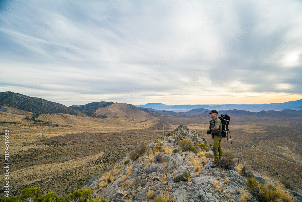 Side view of backpacker standing on summit ridge of Potosi Mountain Side view of backpacker standing on summit ridge of Potosi Mountain