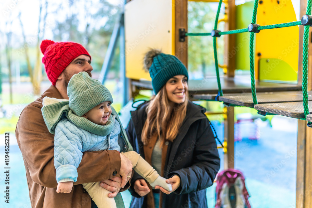 Happy family enjoying time together at playground in winter Happy family enjoying time together at playground in winter