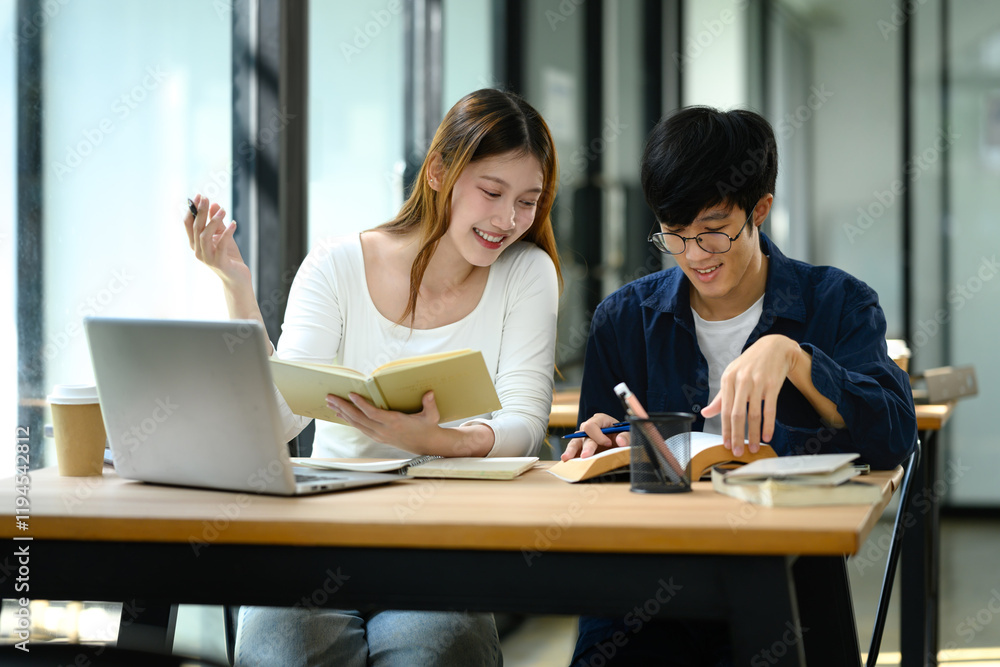 Cheerful female student explains her notes while working with classmate on their studies Cheerful female student explains her notes while working with classmate on their studies