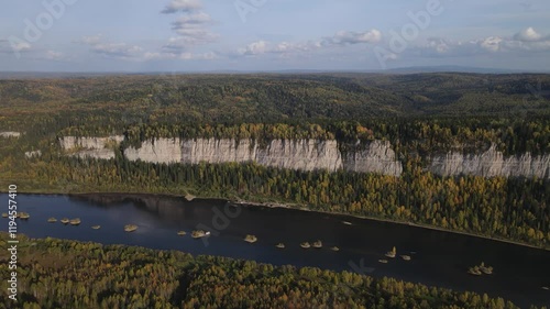 Flight over a sunny autumn forest and river