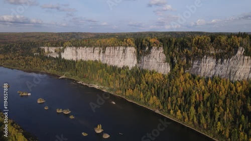 Flight over a sunny autumn forest and river