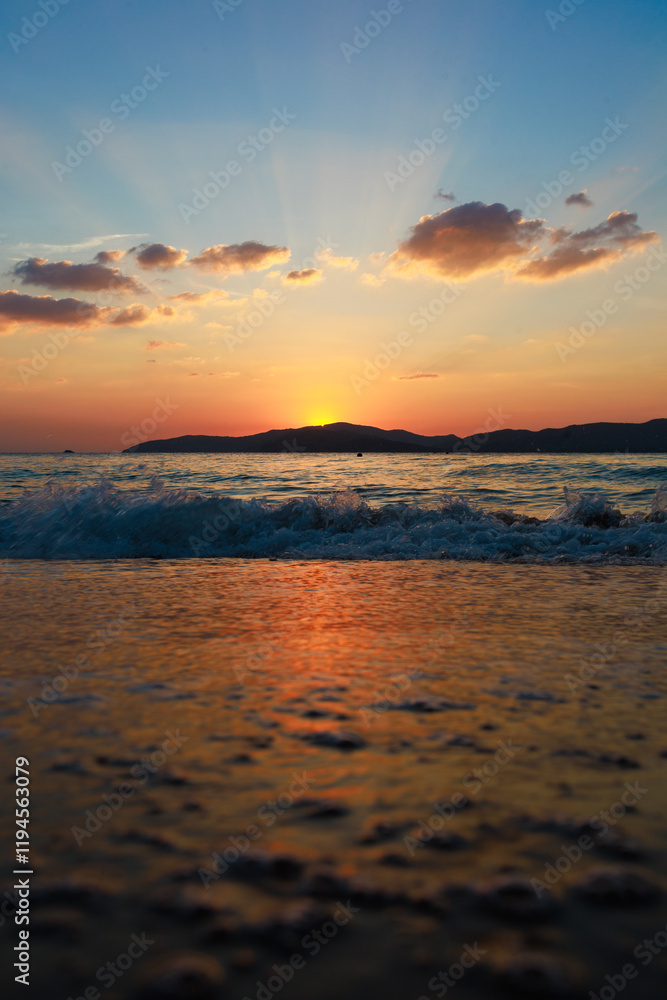Picture of the beach at sunset with the foreground being a sandy beach and sea water. The background is Khram Yai Island. The name of the beach is Haad So, Chonburi Province, Sattahip District. Picture of the beach at sunset with the foreground being a sandy beach and sea water. The background is Khram Yai Island. The name of the beach is Haad So, Chonburi Province, Sattahip District.