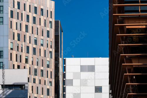 Contemporary urban architecture, showcasing modern materials and design against a vibrant blue sky, emphasizing innovation and progress in city landscapes  in Poblenou in Barcelona Spain photo