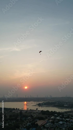 Wallpaper Mural 주황색 석양을 배경으로 여유롭게 비행을 즐기는 엔진 패러글라이더. 
 Torontodigital.ca