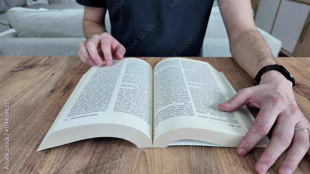 man reads a book and turns pages at home. man reads a book and turns pages at home.