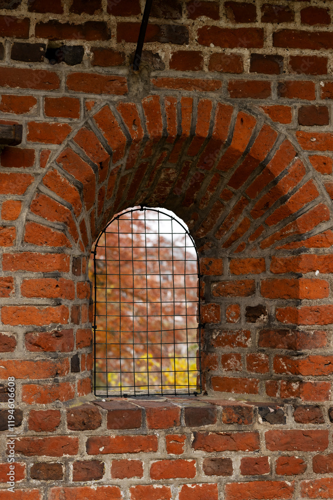 Fototapeta premium Small grated window in the thick brick wall surrounding Frederiksborg Castle