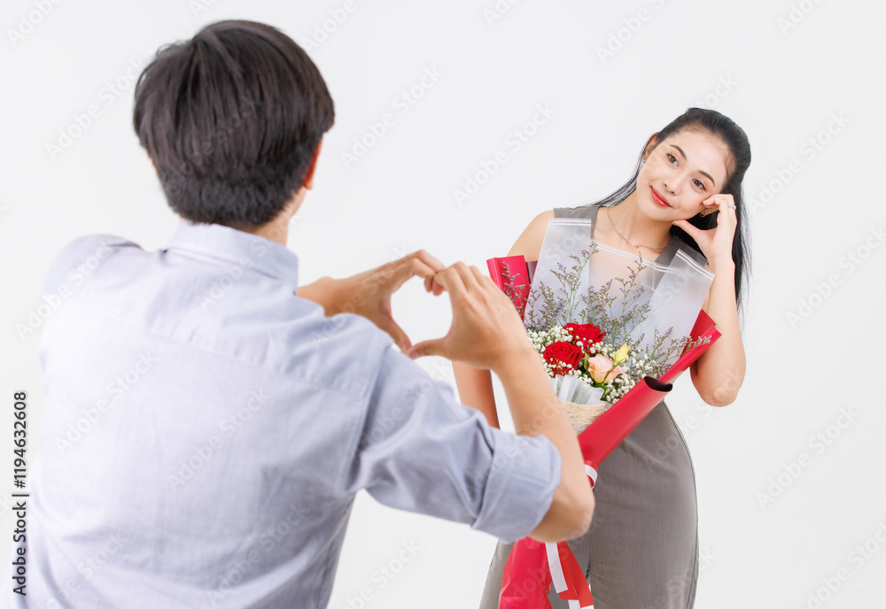 Portrait of young asian happy attractive cheerful couple love holding bouquet red rose make symbol heart shape from hand for Valentine's day enjoy romantic posing to camera smiling on white background Portrait of young asian happy attractive cheerful couple love holding bouquet red rose make symbol heart shape from hand for Valentine's day enjoy romantic posing to camera smiling on white background