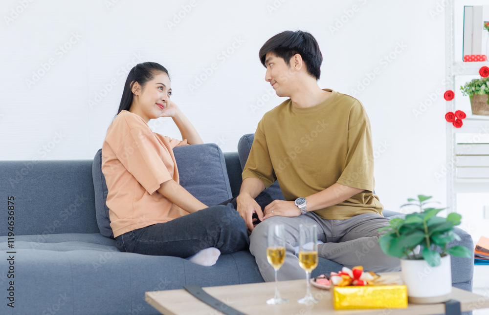 Asian young happy attractive couple love sweethearts smile hugging talking sitting on cozy sofa in living room at home to celebrating anniversary surprise enjoy good time together. Asian young happy attractive couple love sweethearts smile hugging talking sitting on cozy sofa in living room at home to celebrating anniversary surprise enjoy good time together.