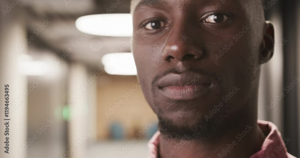 Close-up of confident businessman in office hallway, looking at camera Close-up of confident businessman in office hallway, looking at camera