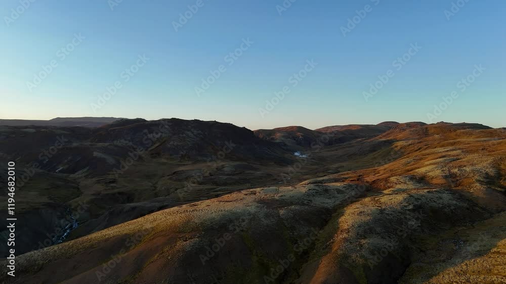 Golden hour bathes Iceland’s volcanic valleys in warm light, revealing rugged textures and winding waterfalls. A serene, untouched landscape that captures the essence of Nordic wilderness.