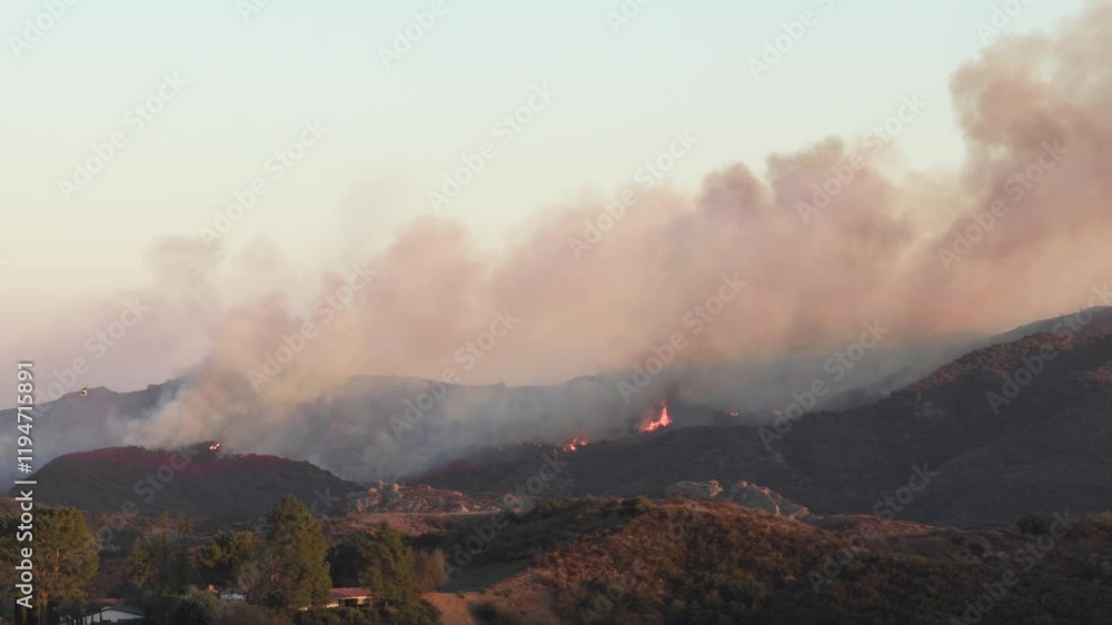 A fierce wildfire is raging in the hills around Los Angeles, prompting urgent aerial firefighting and mandatory evacuations. Thick smoke blankets the area as homes are threatened by the flames A fierce wildfire is raging in the hills around Los Angeles, prompting urgent aerial firefighting and mandatory evacuations. Thick smoke blankets the area as homes are threatened by the flames