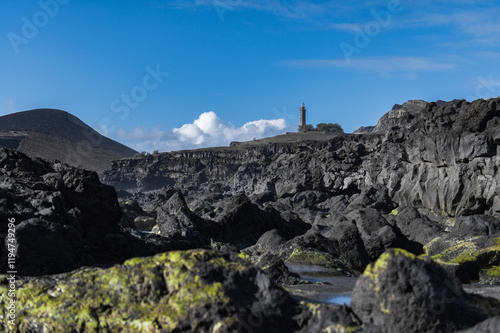 Farol da Ponta dos Capelinhos lighthouse at Faial island of the Azores, Portugal. Former beacon on the Atlantic Ocean coast. Eruption of Capelinhos volcano. photo