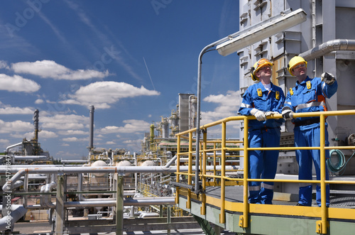 group of workers professional equipment in a petroleum refinery - modern buildings and industrial facilities for the production of fuel and gas