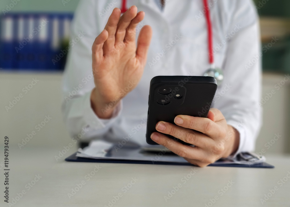 © Nadzeya - Doctor conducts telemedicine consultation while holding a smartphone in a modern medical office © Nadzeya - Doctor conducts telemedicine consultation while holding a smartphone in a modern medical office