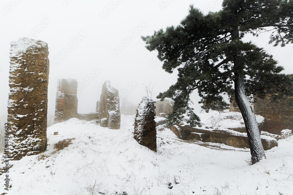 Snow-covered remains of the walls of the upper courtyard of the castle ruins in winter. Stary Jicin. Moravia. Czech Republic.