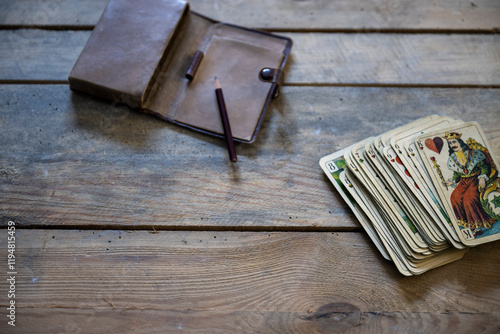 Vintage Spielkarten und Lederetui auf rustikaler Holzoberfläche photo