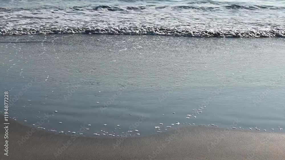 Ocean, slowly moving sea water on the sandy beach of Kamakura during sunset with space for text in Japan. Ocean, slowly moving sea water on the sandy beach of Kamakura during sunset with space for text in Japan.