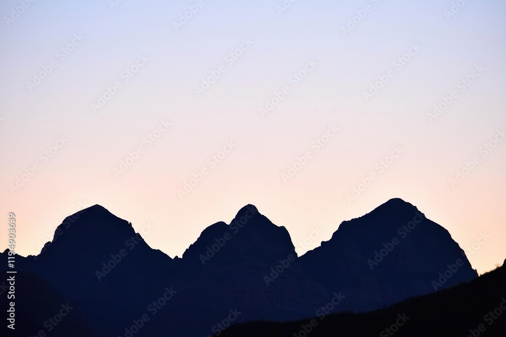 Obraz premium Mountain Range Gradient: Mountains in silhouette with a gradient sky from dark blue at the peak to a light blue at the base