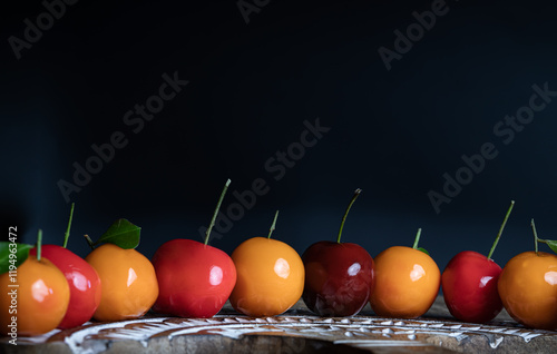 Obraz na płótnie View of Deletable imitation fruits (Kanom look choup) in the shape of fruits has a sweet taste on wooden cutting board. Traditional thai sweet treats made from mung beans and coconut milk, and glazed w salonie