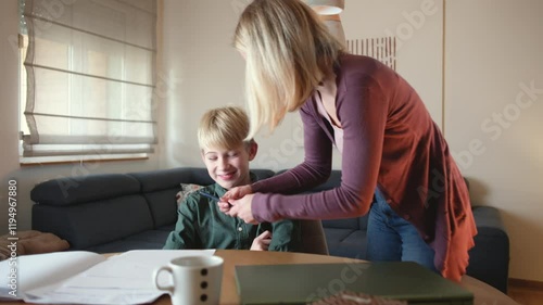 A mother, helping her son with his homework. They are using a laptop to search for information and solve tasks together.