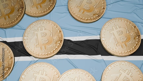 Several bitcoins are laid out on the flag of Botswana photo