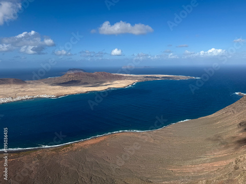 Breathtaking view from above from Mirador del Rio view point of Atlantic ocean, volcanic landscape and La Graciosa island on sunny day