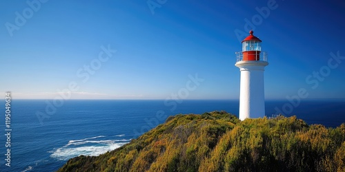 Lighthouse at Cape Point with red top on white tower overlooking blue ocean and greenery under clear sky near Cape of Good Hope South Africa
