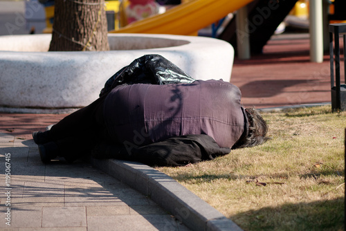Canvas Print Rear view of homeless elder people lying on the street and falling asleep in sunny winter day in Shanghai, China