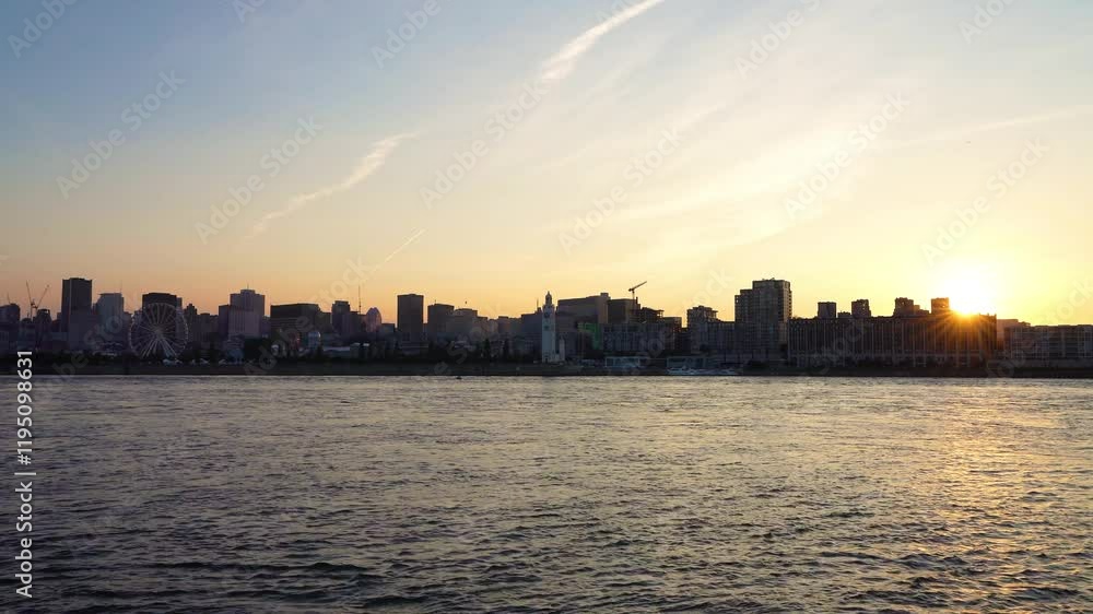Old Port of Montreal and downtown skyline at night. Colorful buildings lights reflected in water. Montreal city, Quebec, Canada. Ferris wheel.
