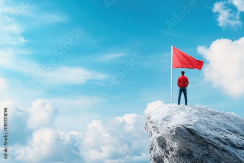 Man on Cliff with Red Flag Against Blue Sky Symbolizing Leadership and Motivation for Success photo