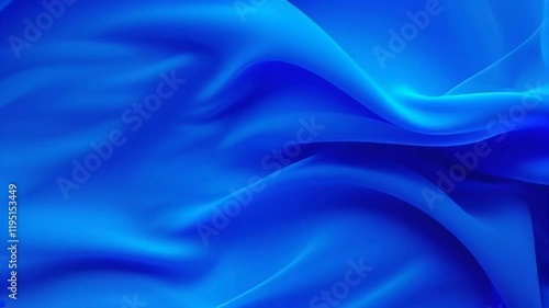A serene blue fabric creates smooth waves, highlighting texture and light, evoking calmness and elegance through artistic motion.