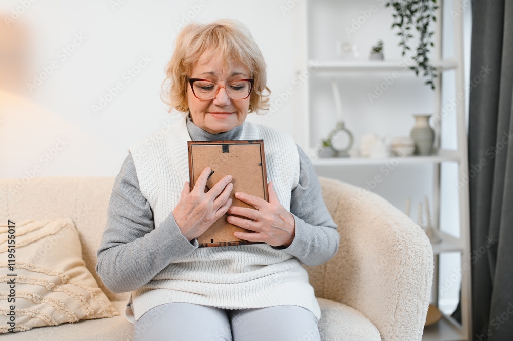 Sad old elderly with depression looks at photograph of her family with nostalgia,remembrance, Depressed senior woman holding picture frame,sitting alone Sad old elderly with depression looks at photograph of her family with nostalgia,remembrance, Depressed senior woman holding picture frame,sitting alone