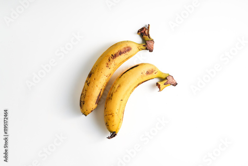 common banana with black spots or blemish on its skin, isolated on white background photo