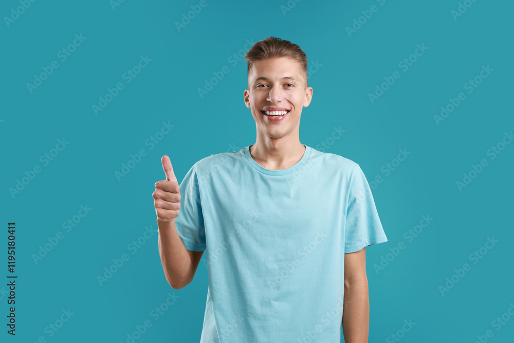 Happy man showing thumbs up on light blue background. Like gesture Happy man showing thumbs up on light blue background. Like gesture