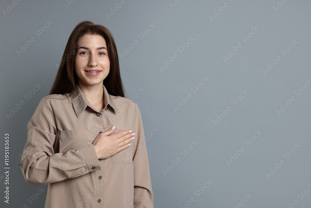 Woman making promise on grey background, space for text. Oath gesture Woman making promise on grey background, space for text. Oath gesture