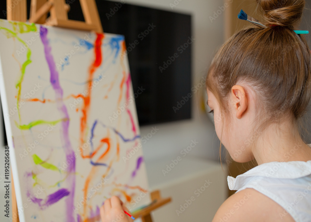 cute little girl draws on an easel. children's painting. cute little girl draws on an easel. children's painting.