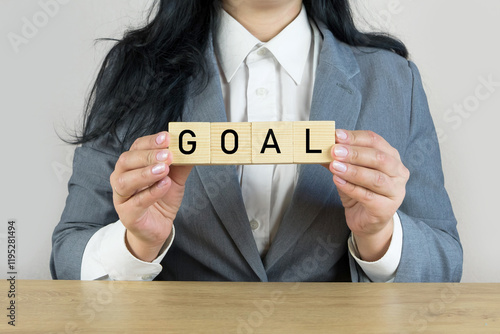 Business woman holding cubes with goals word on the table photo