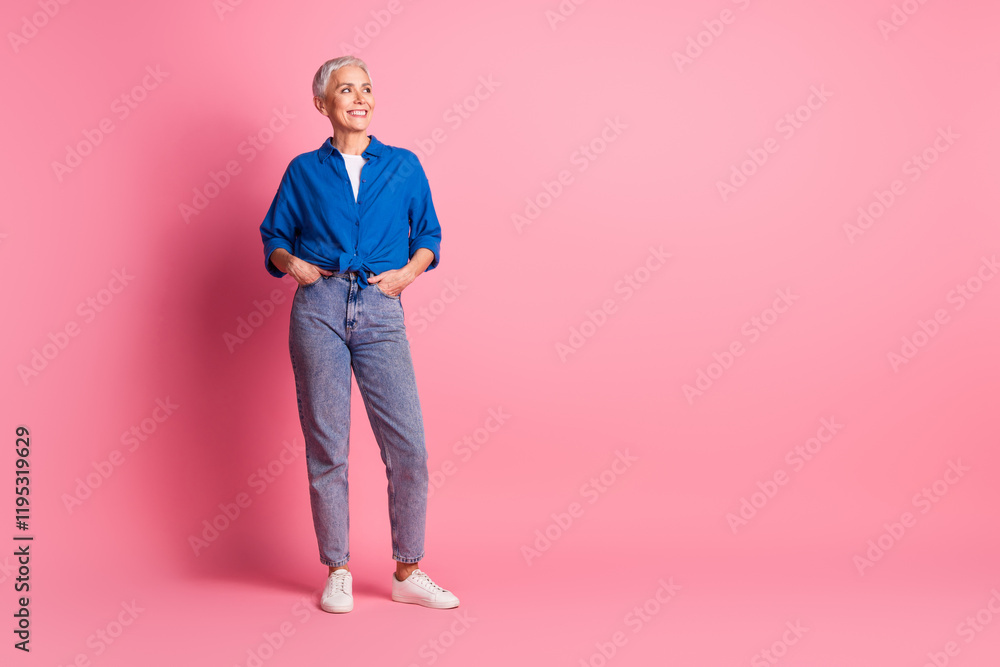 Full length photo of charming positive woman wear blue shirt smiling looking empty space isolated blue color background Full length photo of charming positive woman wear blue shirt smiling looking empty space isolated blue color background