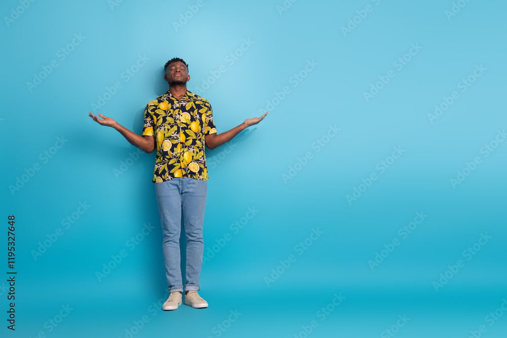 Cheerful young man in stylish shirt strikes a joyful pose against blue backdrop, embodying summer vibes and happiness Cheerful young man in stylish shirt strikes a joyful pose against blue backdrop, embodying summer vibes and happiness