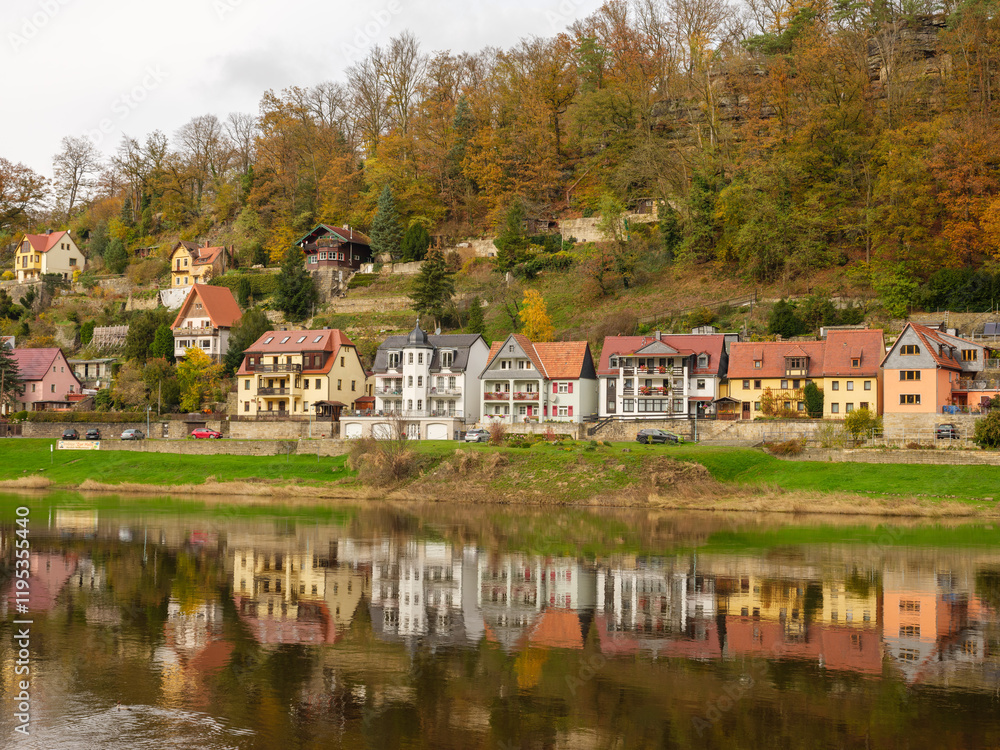 Obraz premium Herbstliche Dorfansicht mit Spiegelung an der Elbe in der Sächsischen Schweiz