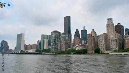 New York, USA, August 17, 2024. Footage walking along the bank of the East River, in front of us the cityscape of Manhattan. On the left the skyscraper headquarters of the United Nations.
