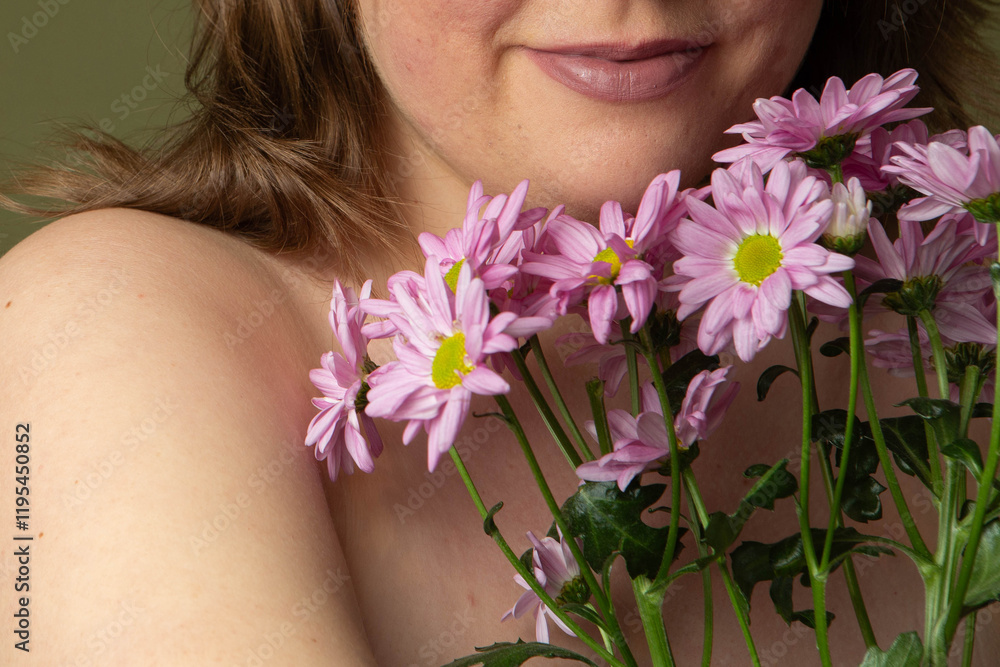 Curvy woman with clear skin imperfections in studio, purple daisy flowers and green background, unrecognizable Curvy woman with clear skin imperfections in studio, purple daisy flowers and green background, unrecognizable