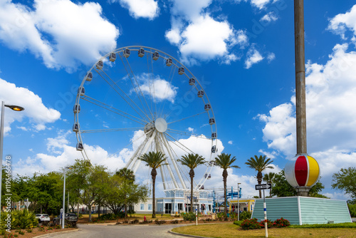 The SkyWheel ferris wheel at Pier Park with lush green palm trees in Panama City Beach Florida USA